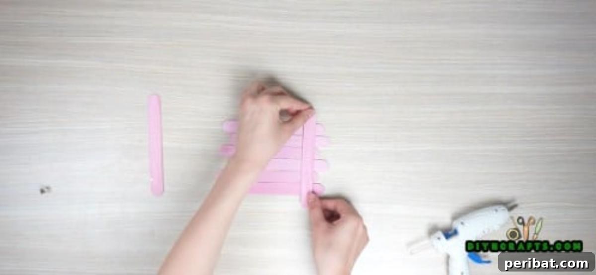 Transform Popsicle Sticks into Adorable Coasters 4 Detailed view of hot glue application for securing popsicle sticks for a square coaster.