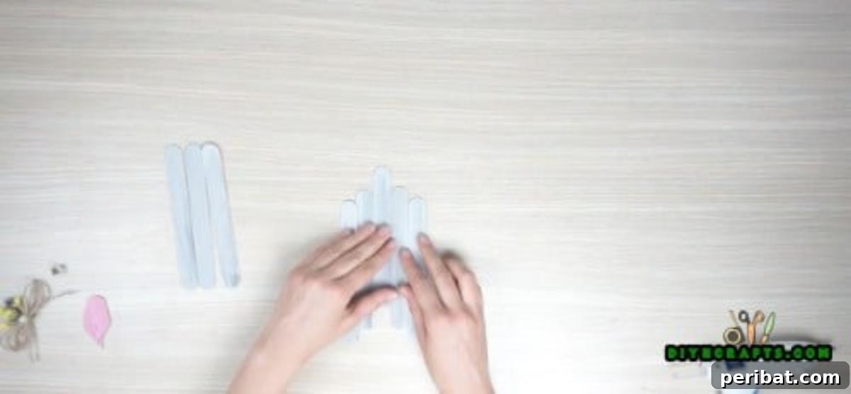 Transform Popsicle Sticks into Adorable Coasters 6 Arranging popsicle sticks to form the house shape for the DIY coaster.
