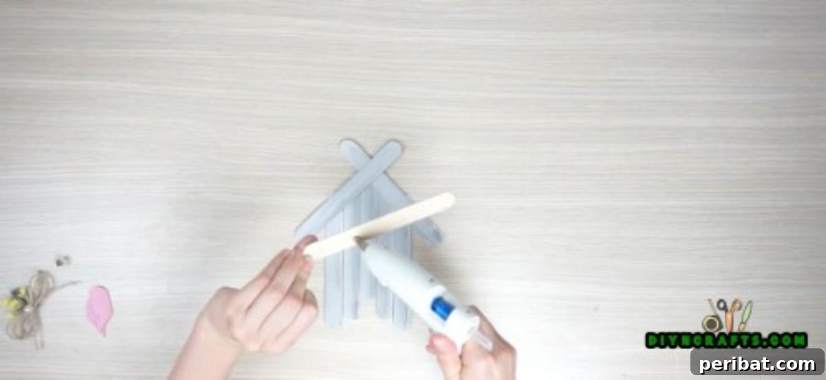 Transform Popsicle Sticks into Adorable Coasters 8 Adding a base stick to reinforce the bottom of the DIY house coaster.