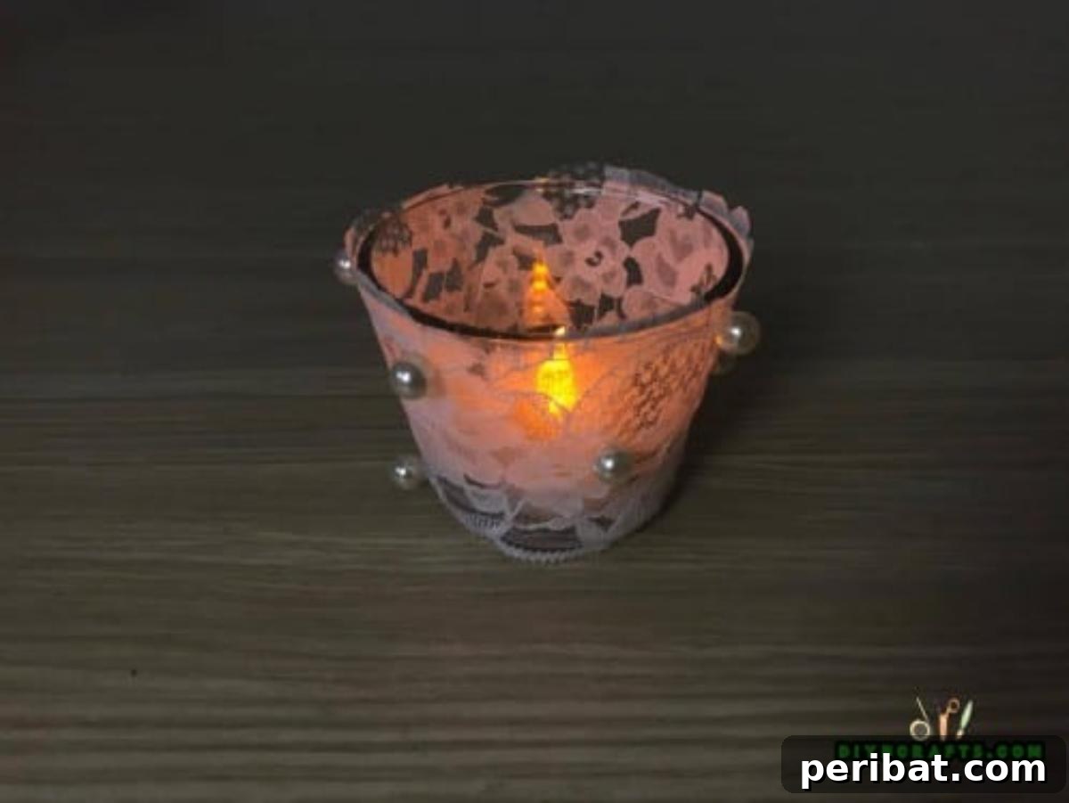 DIY Beautiful Candle Holders From Simple Materials 14 Finished lace candle holder, adorned with a small embellishment, showcasing its delicate and elegant design.