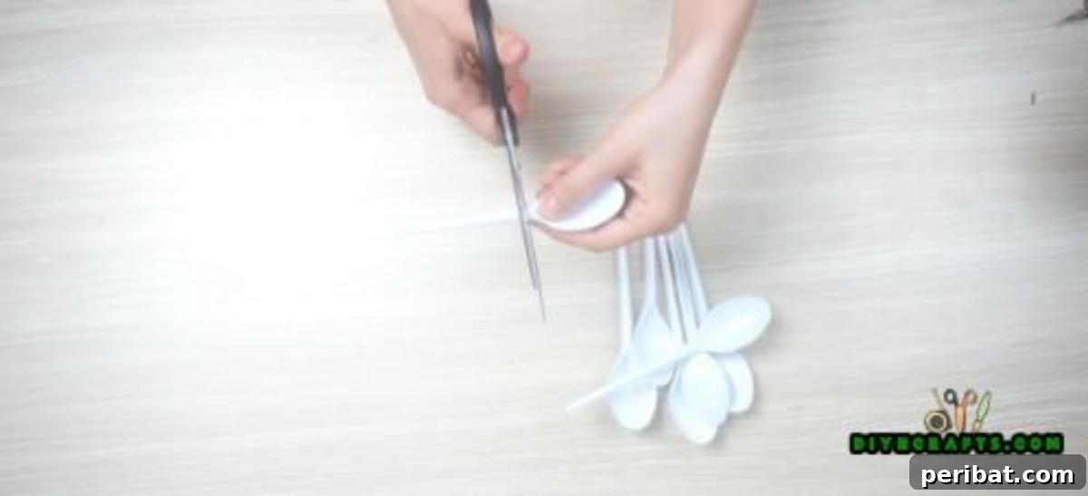 DIY Beautiful Candle Holders From Simple Materials 7 Cutting the bowls off plastic spoons to prepare them for the DIY flower petal candle holder project.