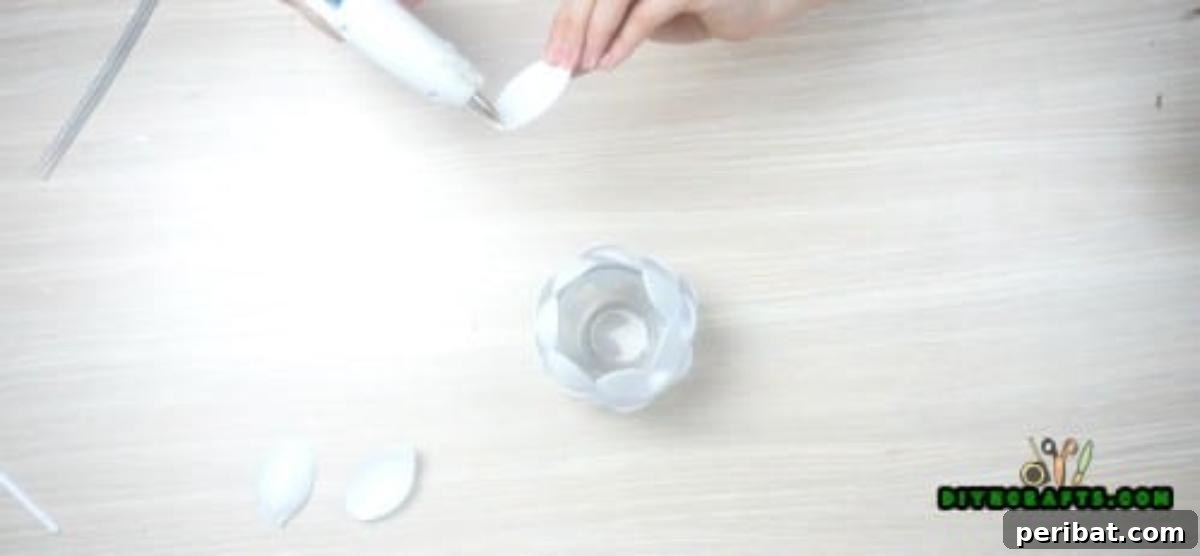 DIY Beautiful Candle Holders From Simple Materials 10 Adding a second overlapping layer of plastic spoon bowls below the first, building up the floral design of the candle holder.
