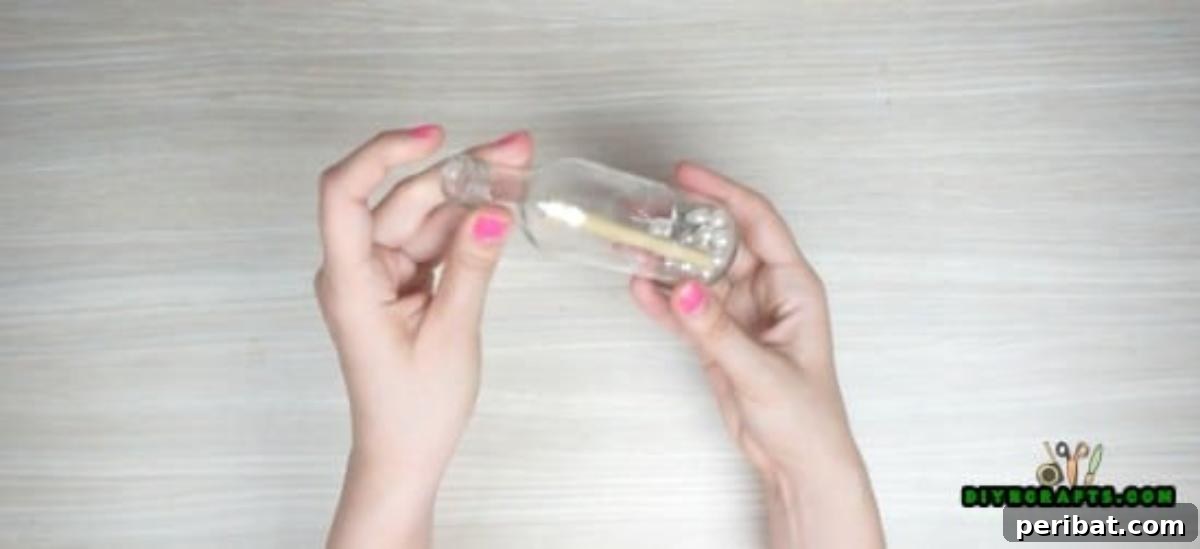 Adding a piece of bamboo to the filled glass bottle for aesthetic appeal.