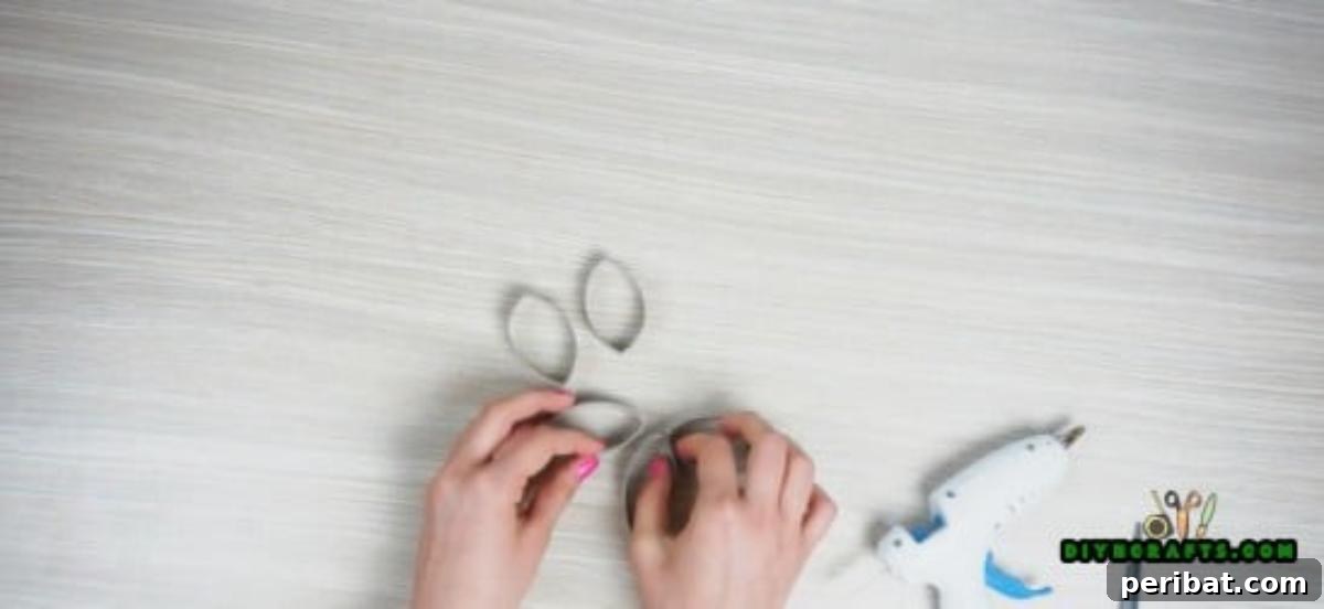 Gluing five paper roll slices together at their tips to form a beautiful flower shape for a candle holder.