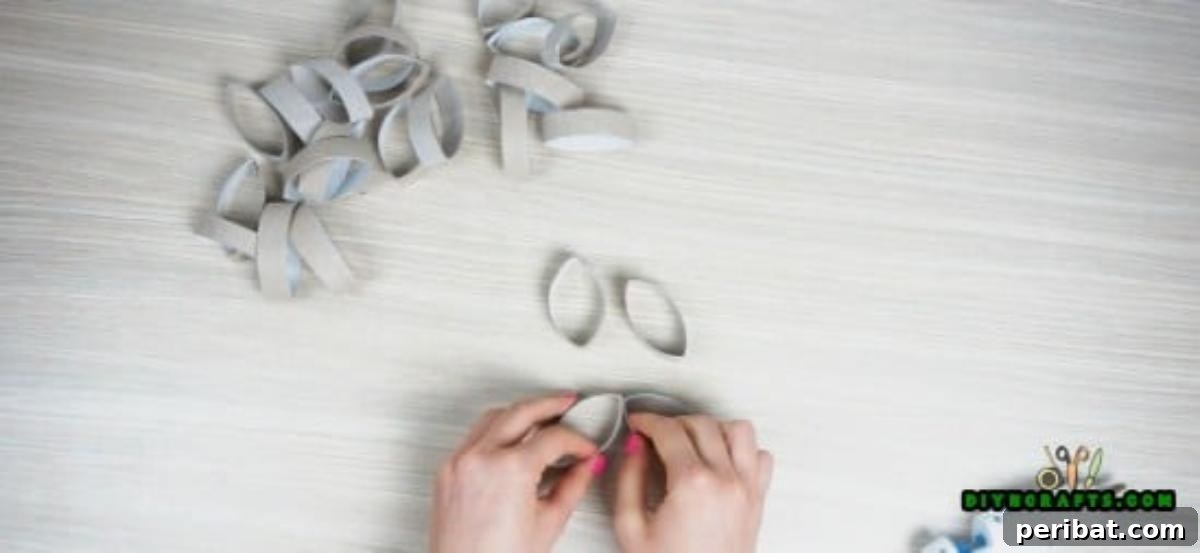 Gluing four paper roll slices to create a small flower shape, a component of the second candle holder design.