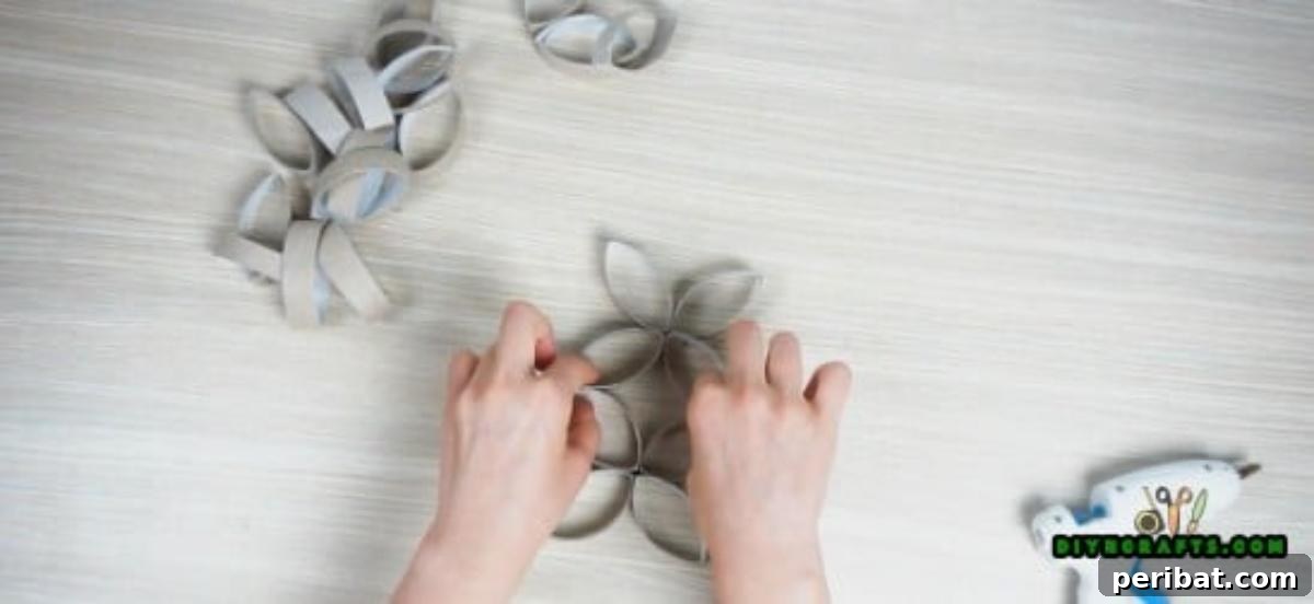 Two four-petal paper roll flower units glued together, forming a stacked component for the candle display.