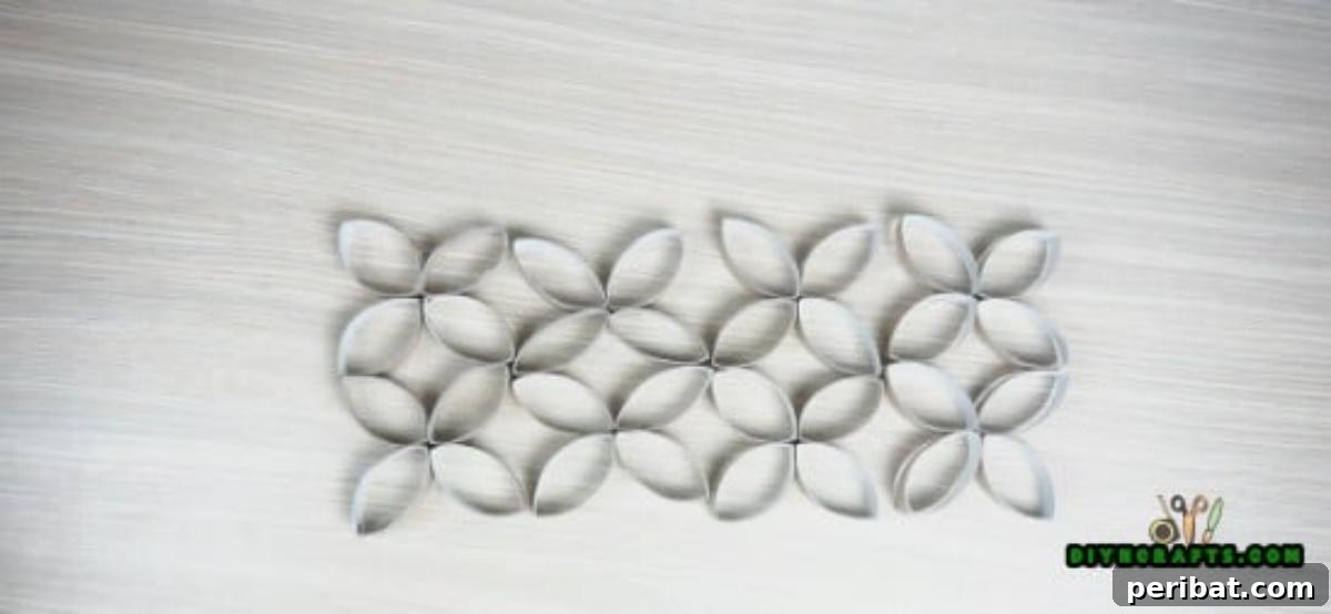 Four identical stacked paper roll flower components, ready to be assembled into a larger candle holder.