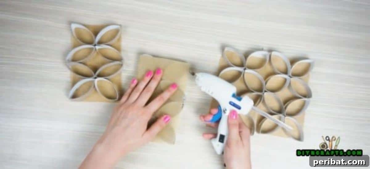 Applying decorative paper onto a stacked paper roll flower component, preparing a panel for the candle display.