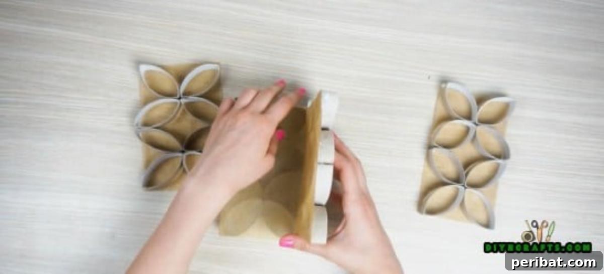 Assembling the four decorated panels to create a four-sided paper roll candle display.
