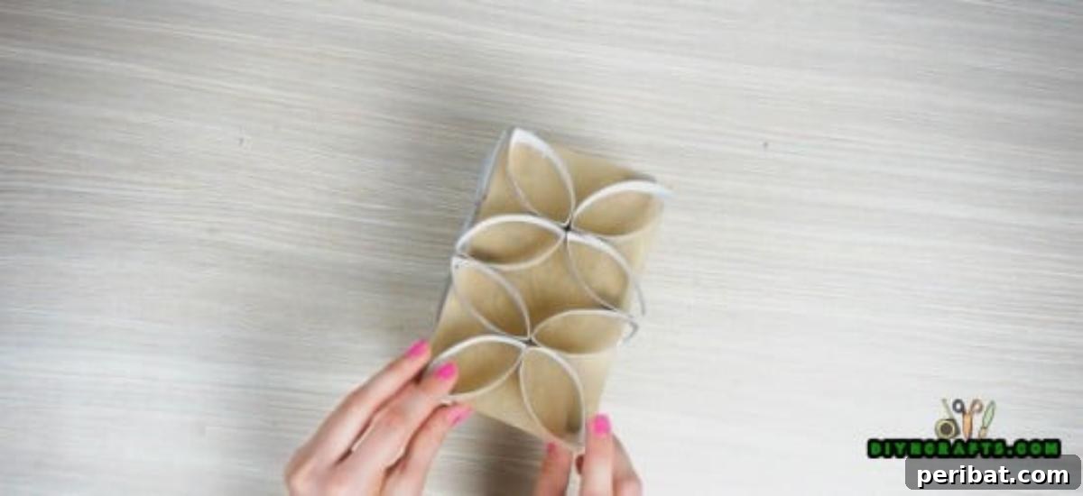 Adding final embellishments to the exterior of the assembled four-sided paper roll candle display.