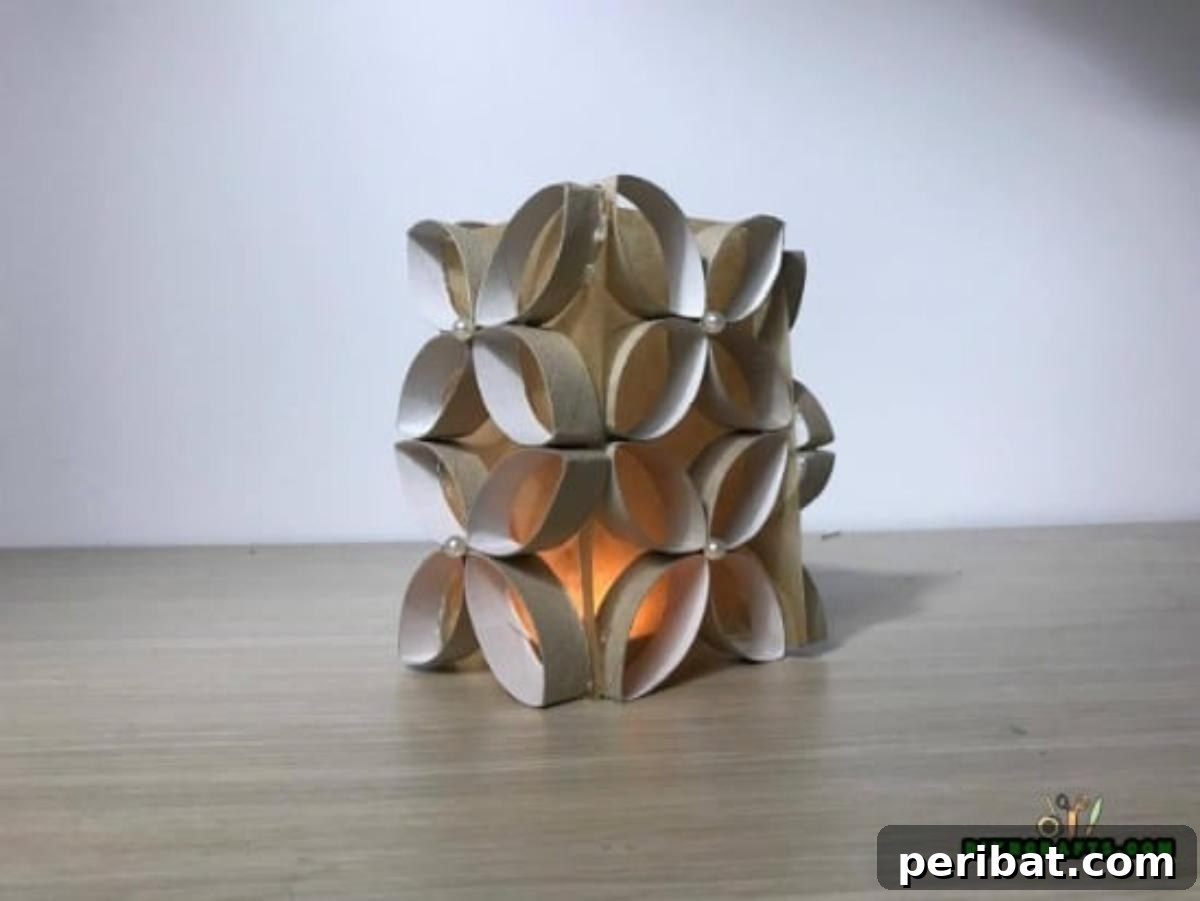 Finished four-sided paper roll candle display with a candle placed inside, ready to illuminate a space.