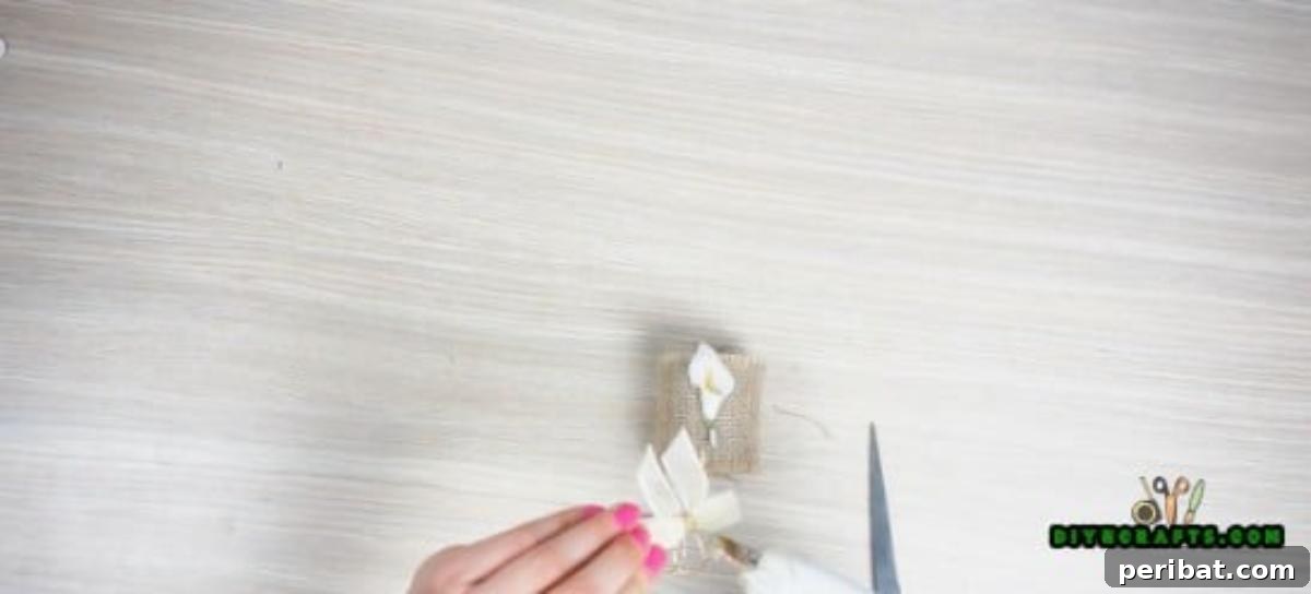 A finished DIY napkin ring with burlap and a small decorative pearl, ready for use.