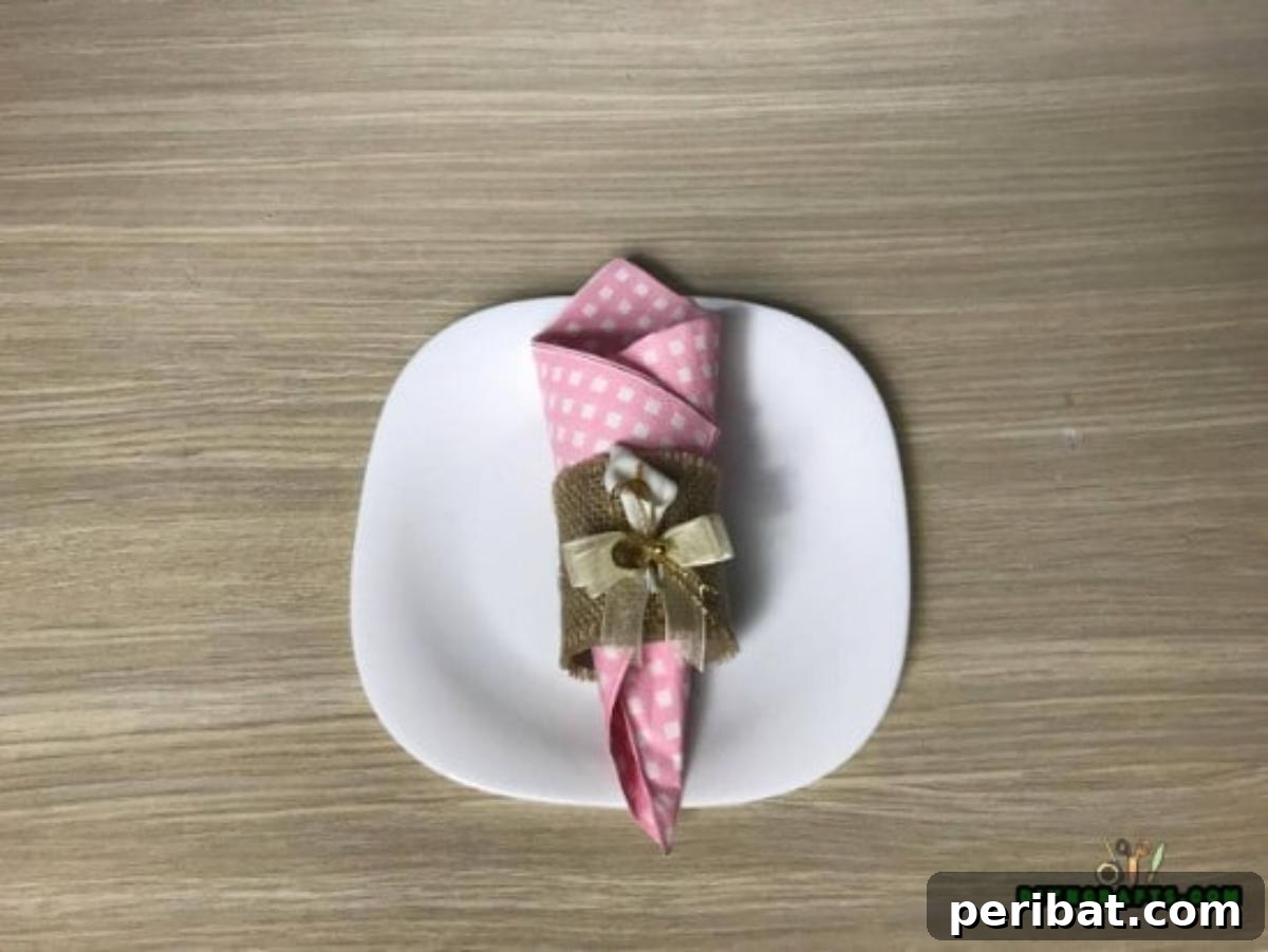 A finished DIY napkin ring with a folded napkin elegantly passed through its center.