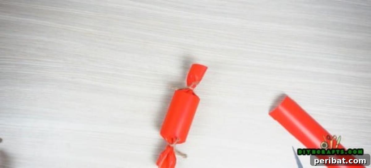 Both ends of the decorative paper roll candy tied off with twine, ready for further embellishment.