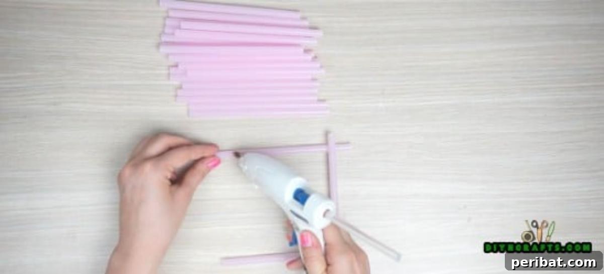 Candle Holder - Step 1: Laying two parallel straws and gluing two perpendicular straws to form a square base