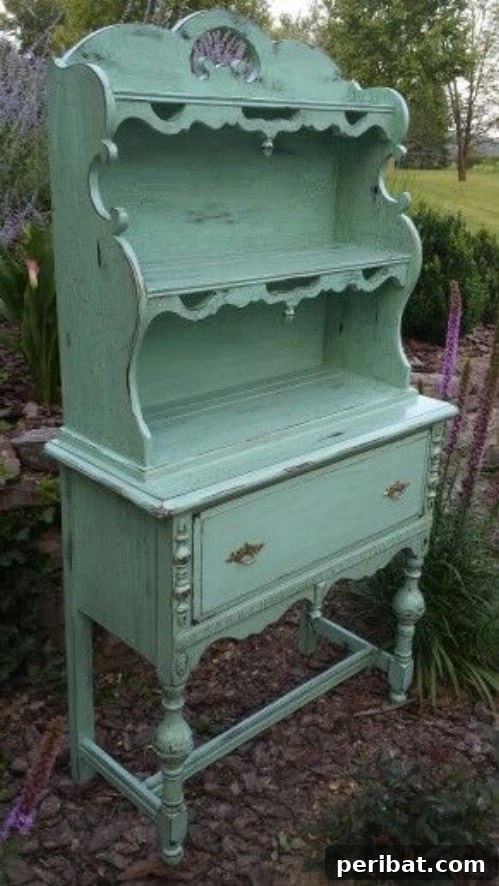 Charming old-fashioned hutch painted in a muted, weathered teal, evoking vintage and antique decor.