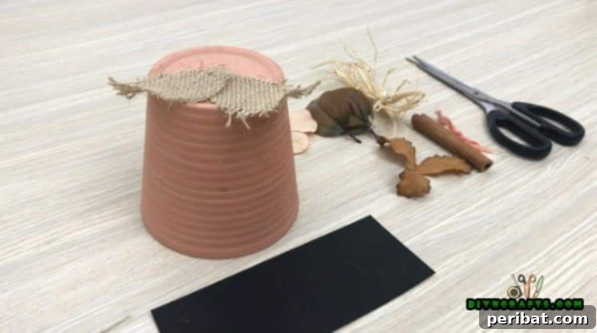 Gluing a leaf-shaped piece of burlap onto the hot glue on the flower pot base
