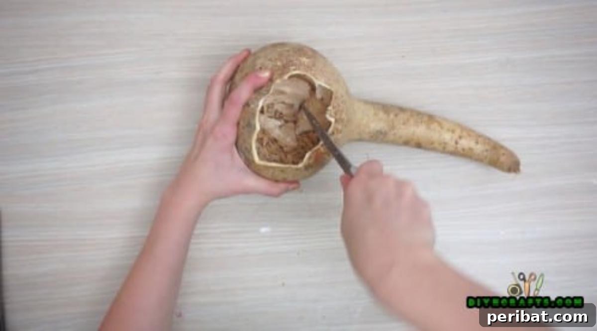 Minutes to Marvelous: 5 Easy Fall DIY Decor Projects 25 Hollowing out the interior of the gourd with a spoon to create a clean, spacious cavity for the floral arrangement.