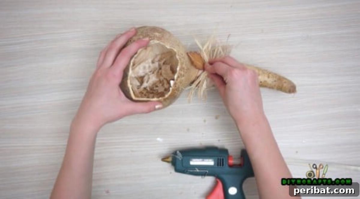 Minutes to Marvelous: 5 Easy Fall DIY Decor Projects 27 Close-up of the straw decoration being meticulously applied to the gourd, adding detail and texture to the fall display.