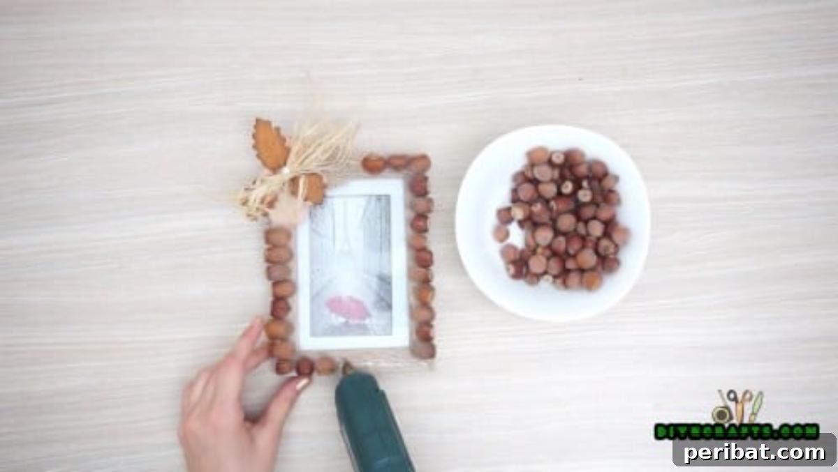 Minutes to Marvelous: 5 Easy Fall DIY Decor Projects 6 Close-up view of the acorns being meticulously glued onto the fall picture frame, ensuring a beautiful, dense arrangement.