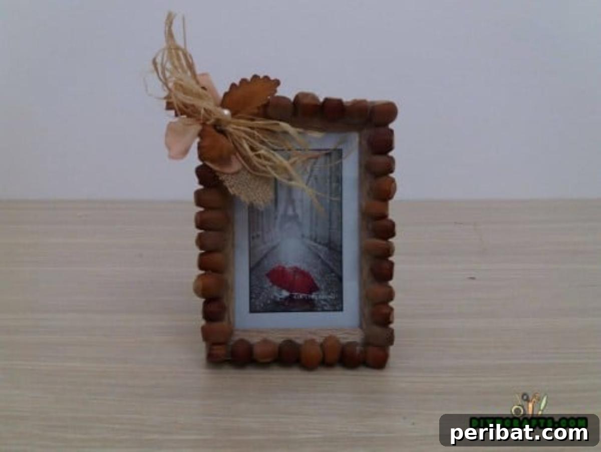Minutes to Marvelous: 5 Easy Fall DIY Decor Projects 7 The completed fall picture frame, beautifully adorned with burlap, vibrant leaves, decorative straw, a pearl, and a border of natural acorns, ready to display.