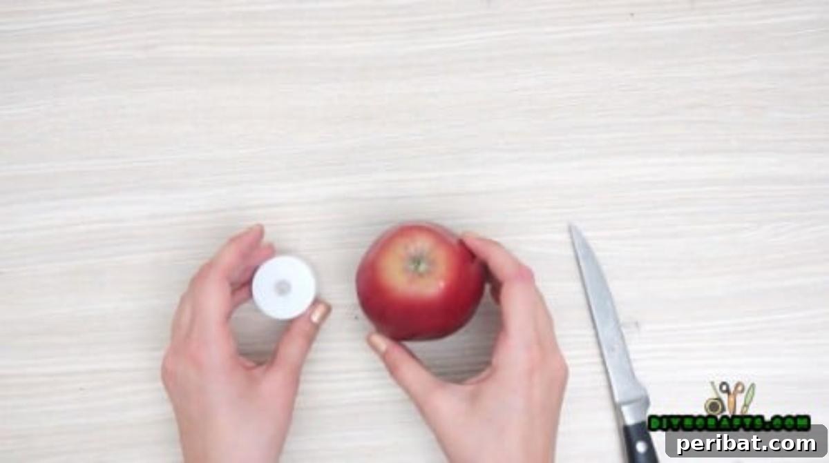 Minutes to Marvelous: 5 Easy Fall DIY Decor Projects 8 Starting the apple votive project with a fresh, crisp apple and an LED votive candle, prepared for crafting.