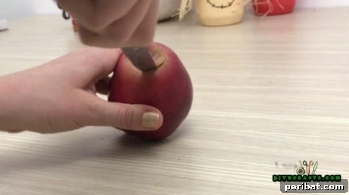 Minutes to Marvelous: 5 Easy Fall DIY Decor Projects 10 Continued hollowing process for the apple votive, demonstrating careful removal of apple flesh to ensure the cavity is snug for the light.
