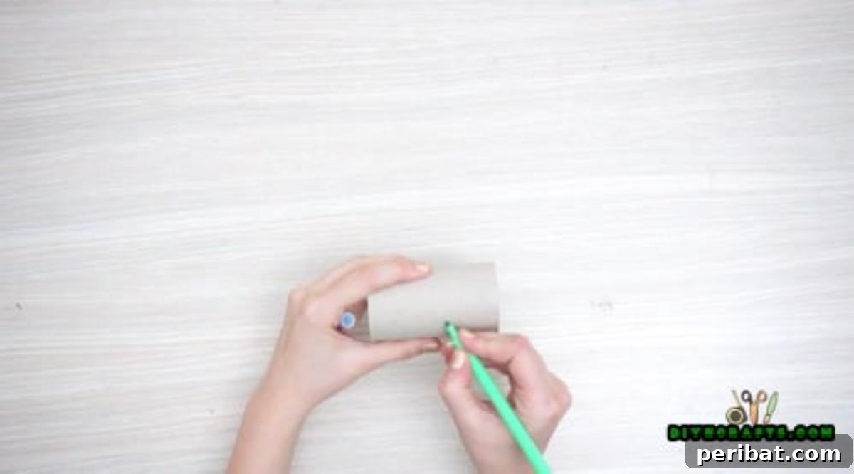 Step 1: Beginning the glowing eyes craft with an empty toilet paper roll and a marker for sketching.