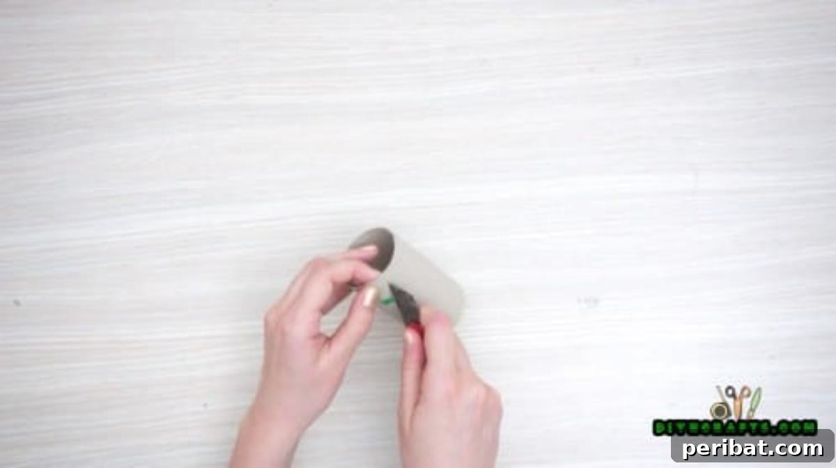 Step 3: Carefully cutting out the drawn eye shapes from the toilet paper roll using an Exacto knife.