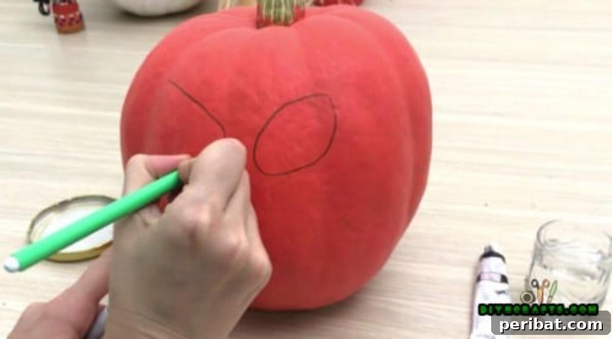 Step 1: Lightly sketching the outlines of eyes onto the pumpkin with a pencil, preparing for painting.