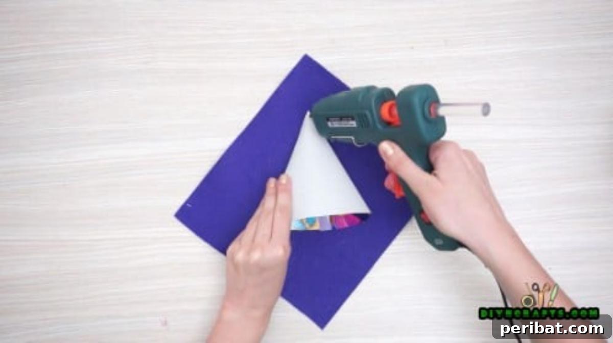 Step 1: Forming the witch's hat using a paper cone and decorative paper, secured with hot glue.