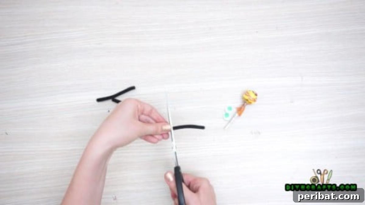 Step 1: Gathering lollipops and cutting black pipe cleaners into segments for spider legs.
