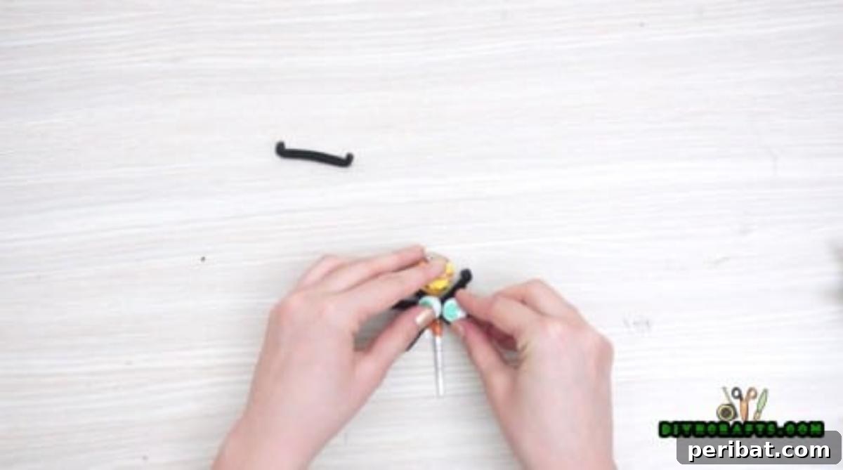 Step 3: Attaching googly eyes to the lollipop candy, bringing the sweet spider to life.