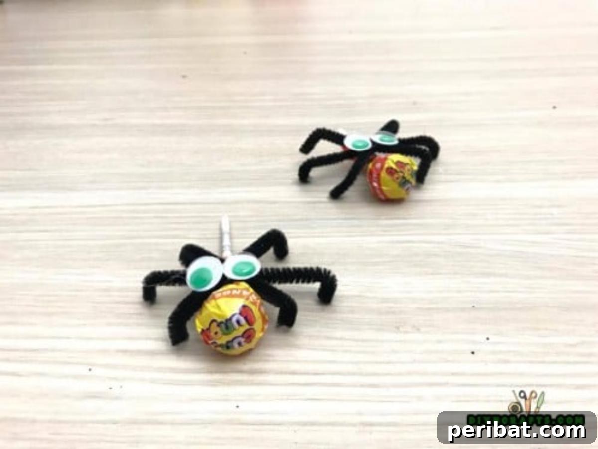 Completed Lollipop Spiders, featuring googly eyes and pipe cleaner legs, ready as sweet Halloween treats.