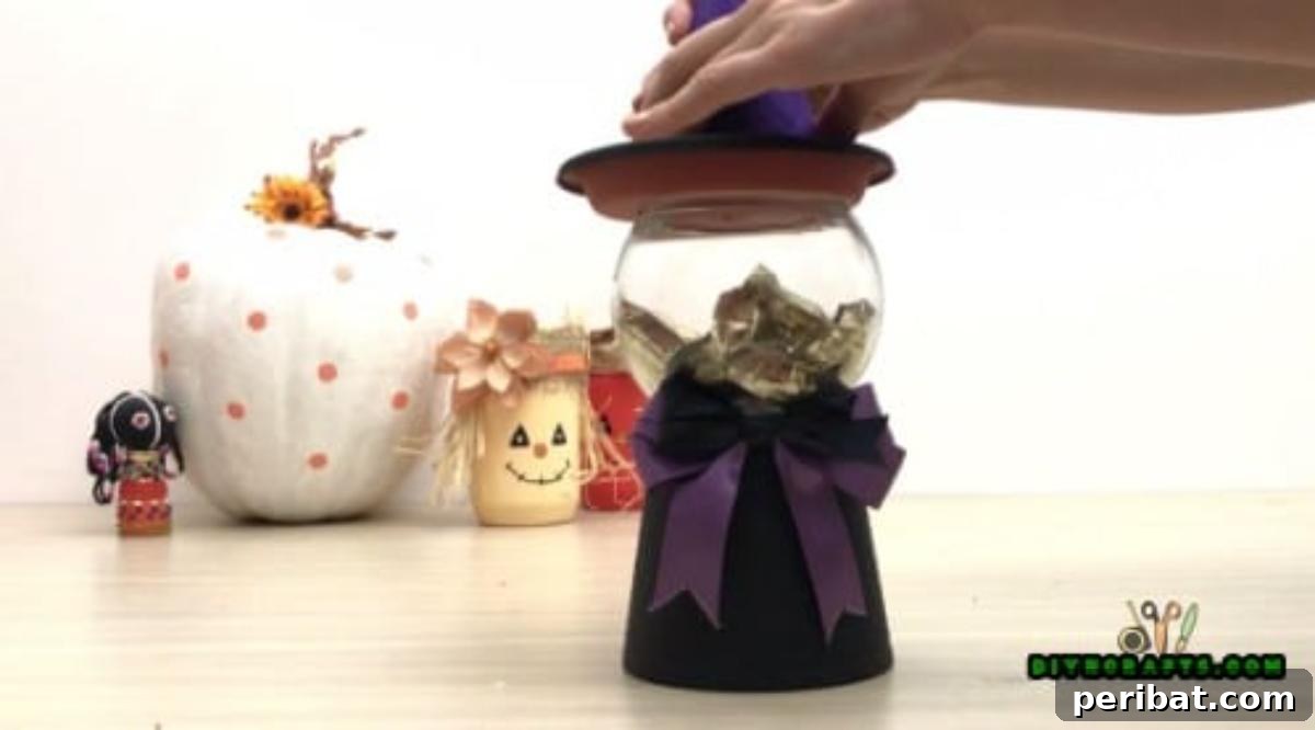 Step 7: Attaching the decorative paper cone to the water collection tray with glue, completing the witch's distinctive hat.