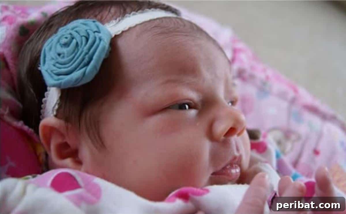 Sweet No Sew Baby Headband Bow, crafted from rolled fabric into a floral shape and attached to a soft headband.