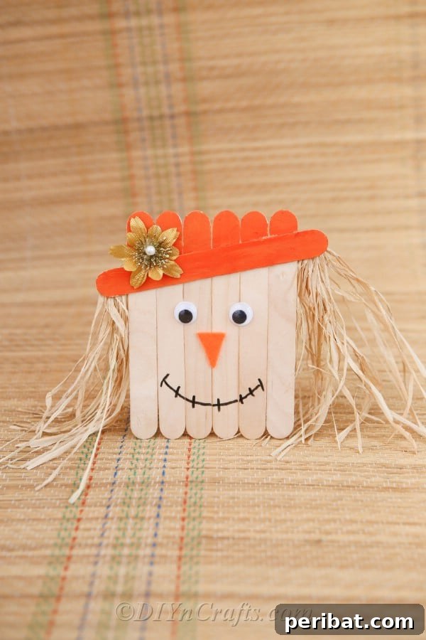 Popsicle stick scarecrow on brown paper