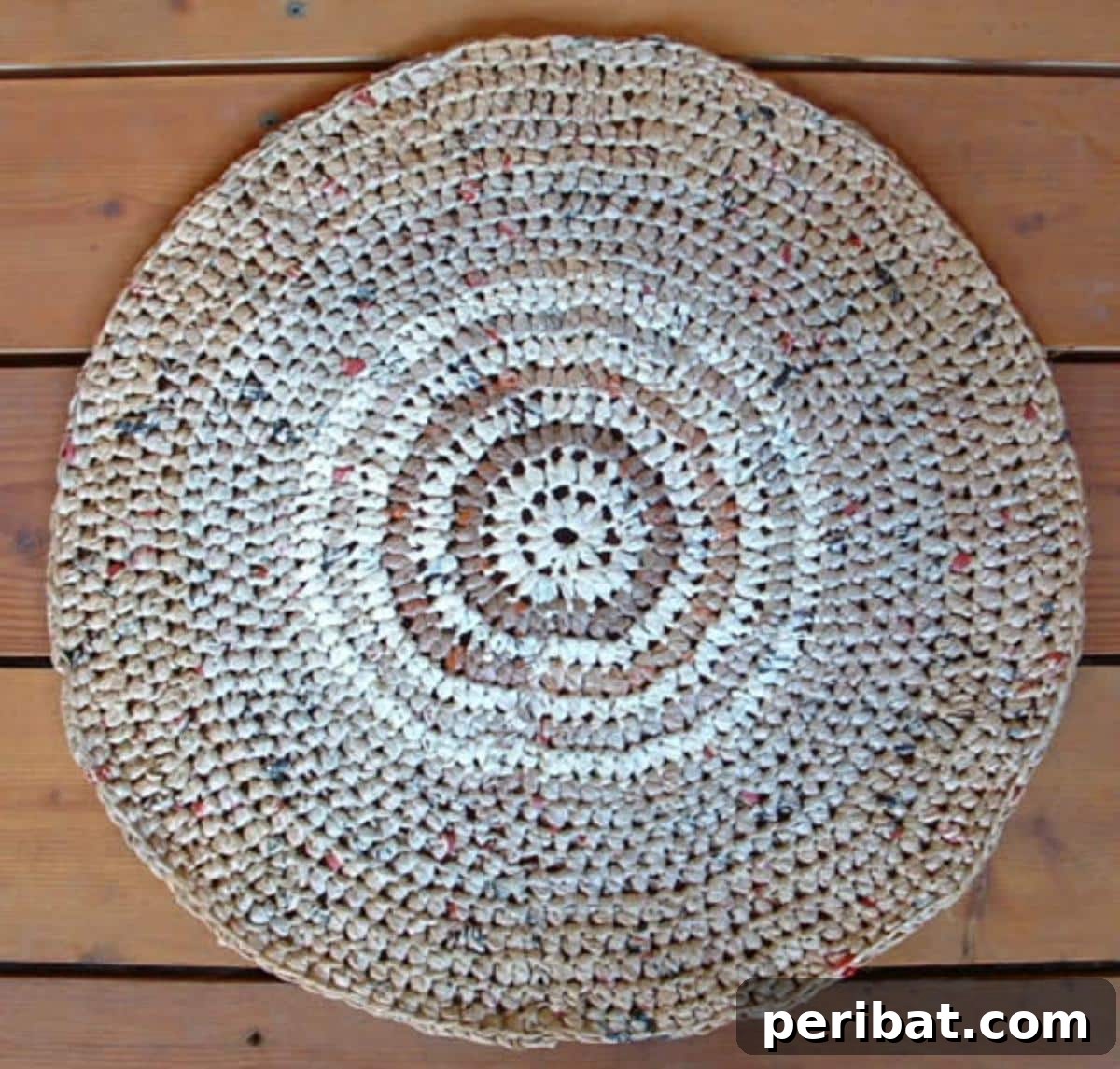 A unique DIY doormat crafted from recycled plastic grocery bags, crocheted together to form a durable and eco-friendly plarn rug.