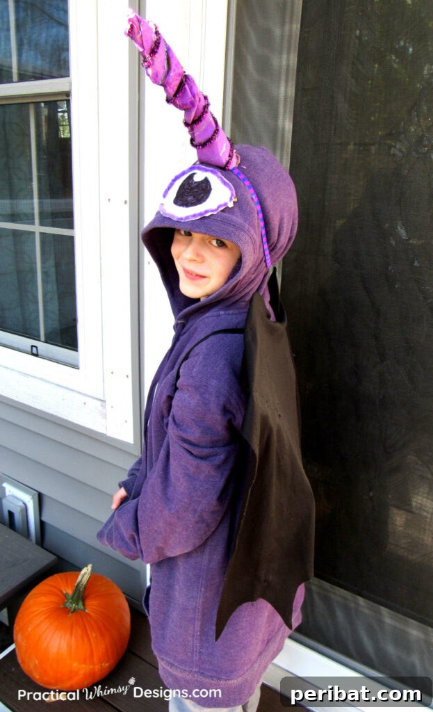 75 Effortless DIY Halloween Costumes That Kids Adore 11 A girl smiling in a vibrant DIY Flying Purple People Eater costume by a window, inspired by the classic song