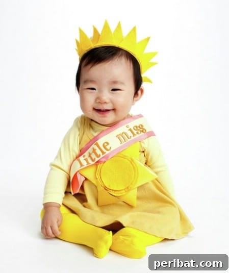 75 Effortless DIY Halloween Costumes That Kids Adore 39 A baby girl dressed as 'Little Miss Sunshine' for Halloween, wearing a yellow dress, crown, and sash, a delightful DIY costume