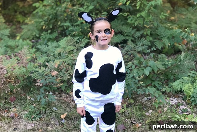 75 Effortless DIY Halloween Costumes That Kids Adore 5 A young girl dressed in a charming no-sew DIY cow costume, perfect for Halloween or themed events