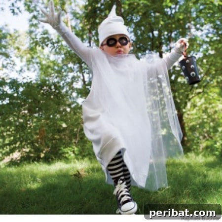 75 Effortless DIY Halloween Costumes That Kids Adore 46 A child in a 'Ghost' costume for Halloween, featuring a white sweatsuit and flowing tulle for an ethereal effect, a creative alternative to a sheet