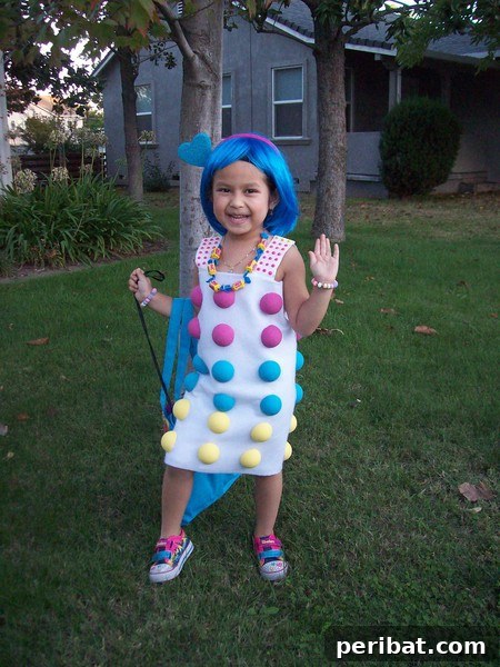 75 Effortless DIY Halloween Costumes That Kids Adore 50 A child in a vibrant 'Dots' candy costume for Halloween, featuring a white dress adorned with colorful Styrofoam balls, a sweet DIY idea
