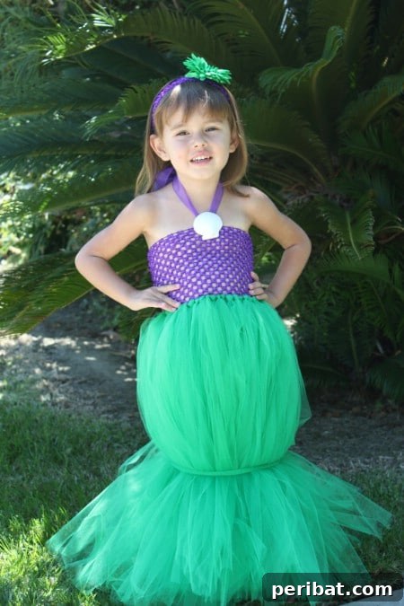 75 Effortless DIY Halloween Costumes That Kids Adore 54 A child dressed as 'The Little Mermaid' (Ariel) for Halloween, featuring a tulle tail and purple sparkly top, a magical DIY costume