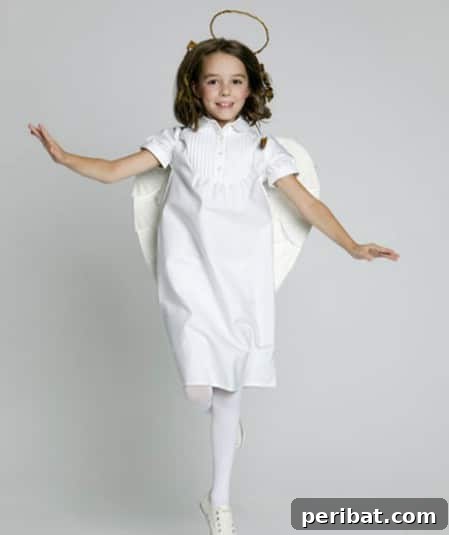 75 Effortless DIY Halloween Costumes That Kids Adore 56 A baby dressed as 'Mommy’s Little Angel' for Halloween, featuring an all-white ensemble, wings, and a halo, a sweet DIY costume