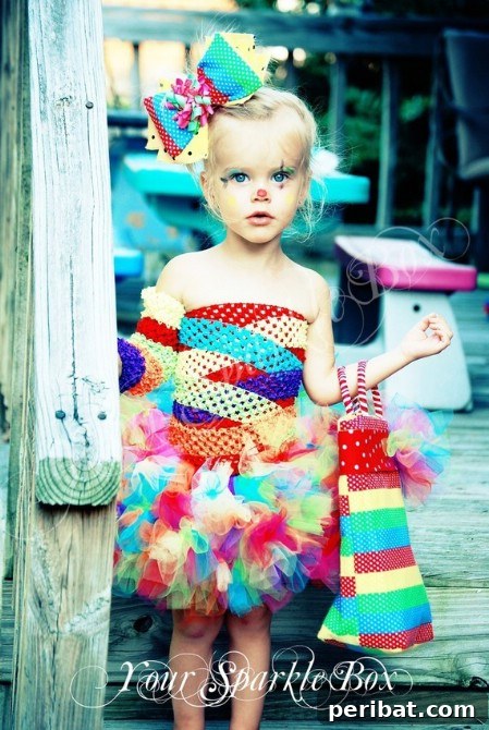 75 Effortless DIY Halloween Costumes That Kids Adore 65 A girl in a vibrant 'Pretty Clown' costume for Halloween, featuring a colorful tutu, matching top, and a large bow, a creative twist on a classic