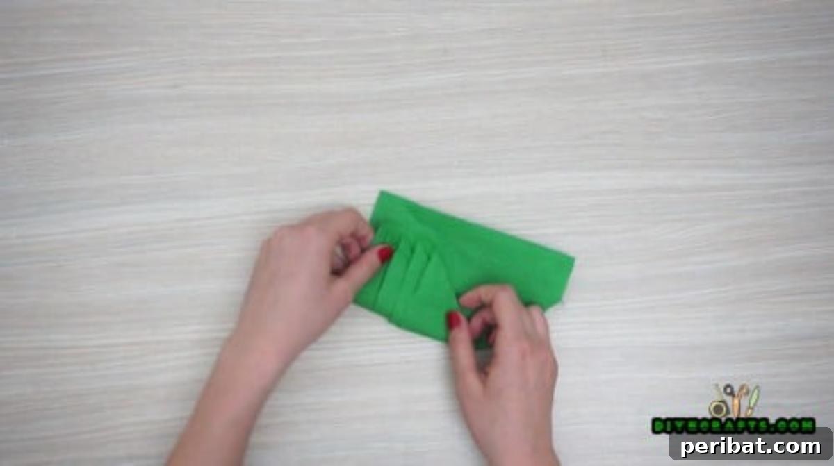5 DIY Christmas Napkin Designs: Festive Folds, Easy Video How-To 12 Tree Napkin - Turn over and fold in edges for a neat Christmas tree napkin design, elegant decor.