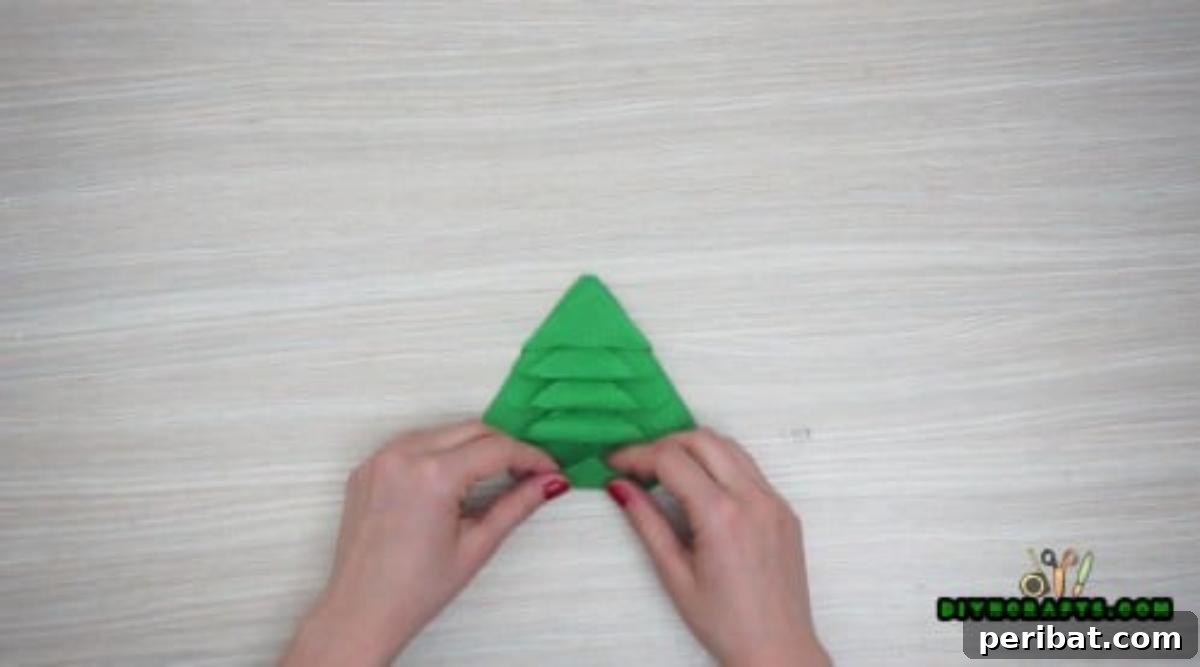 5 DIY Christmas Napkin Designs: Festive Folds, Easy Video How-To 13 Tree Napkin - Fold and tuck corners for the distinct Christmas tree napkin shape, video tutorial helpful.