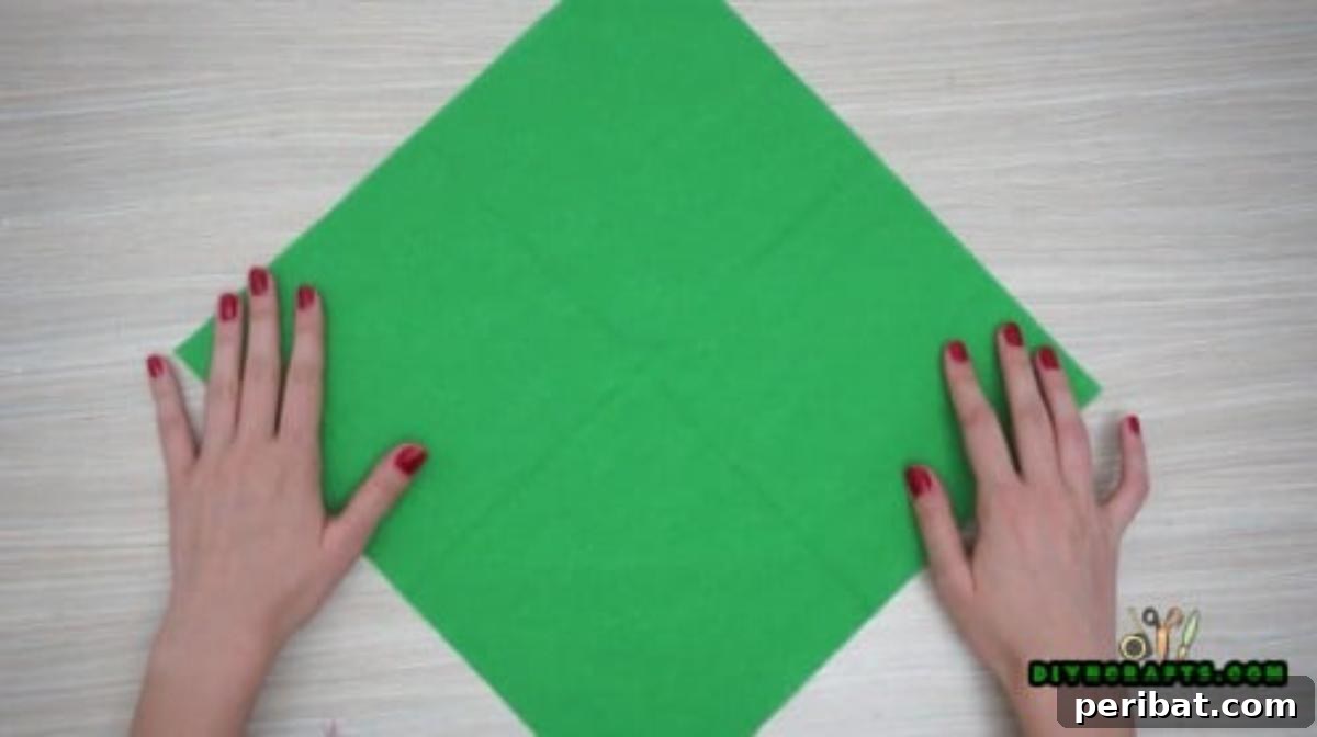 5 DIY Christmas Napkin Designs: Festive Folds, Easy Video How-To 17 Fancy Napkin - Unfold after initial folds to reveal guide lines for sophisticated Christmas table setting.