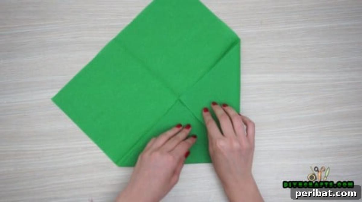5 DIY Christmas Napkin Designs: Festive Folds, Easy Video How-To 18 Fancy Napkin - Fold corners inward to the center, press flat for an elegant Christmas napkin design.